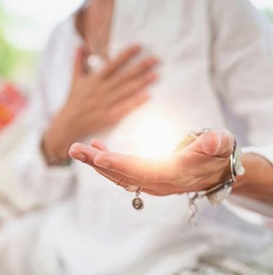 Hand on heart to hand held out with positive reiki energy from healing practitioner.