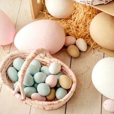 Pastel-colored decorative eggs in baskets and on a wooden surface
