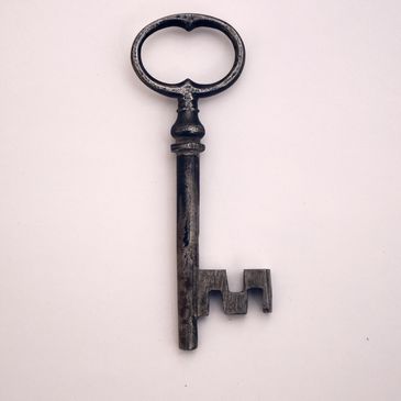An old antique metal key on a plain background
