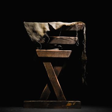 Rustic wooden manger with cloth in dramatic lighting