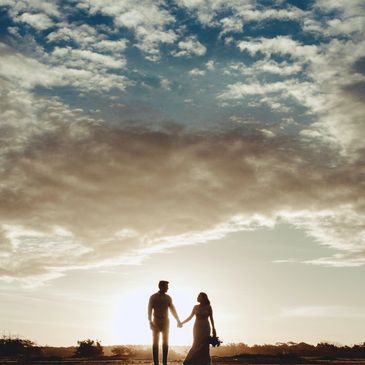Silhouetted couple holding hands at sunset