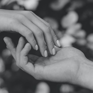 Two hands gently touching in a tender moment