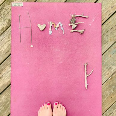 Feet on a yoga mat that says home
