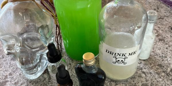 Various potion bottles including one labeled 'Drink Me' on a countertop.