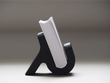 Modern business card holder with sleek design and large bottom curve supporting cards – 2025.
