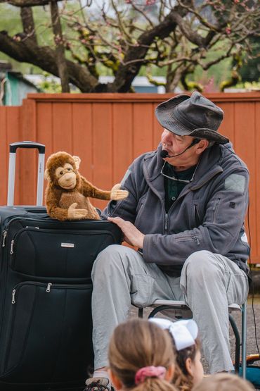Man with a puppet monkey performing outdoors.