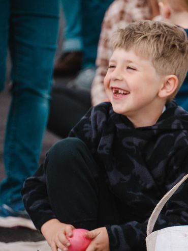 Smiling boy holding a pink ball.