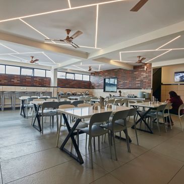 Modern cafeteria with stylish lighting and seating arrangement.