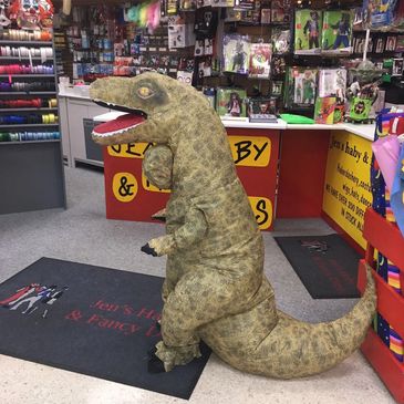 A Boy trying on a T rex costume in our store