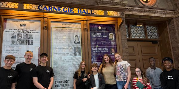 Group of smiling young people outside Carnegie Hall.
