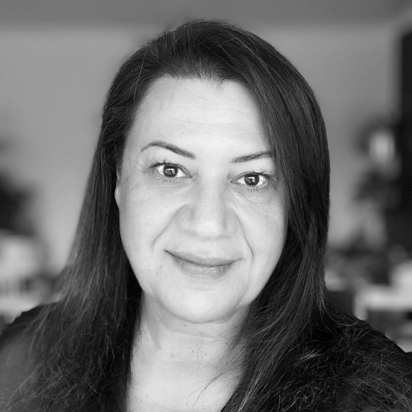 Black and white portrait of a smiling woman with long hair.