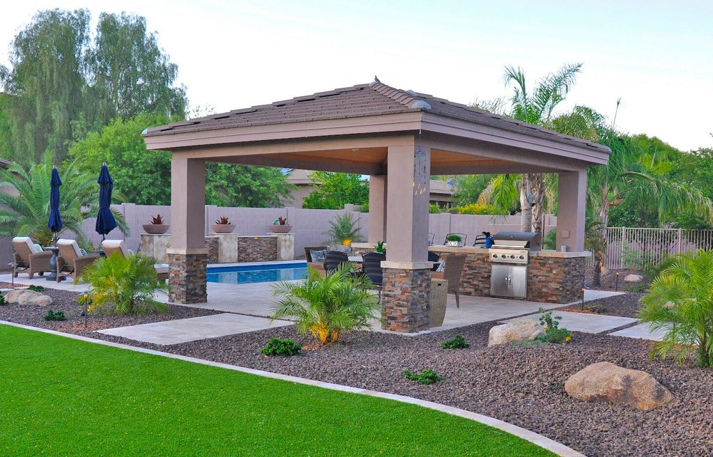 Nice ramada and bbq with stucco and veneer stone finish. Pool with water feature columns and turf. 