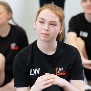 Acting students watching tutor during her drama class.