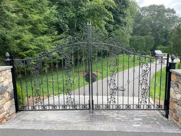 Fabricated hinges welded to metal posts to hang a residential front gate