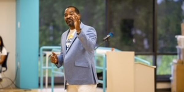 Man speaking in a casual indoor setting.