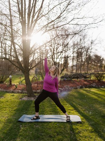 Woman doing yoga outdoors on a mat.