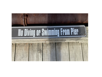Sign stating no diving or swimming from pier.