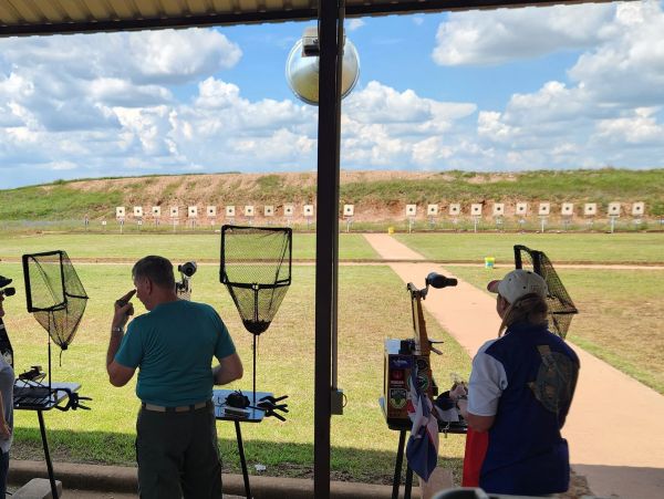 Two people at an outdoor shooting range.