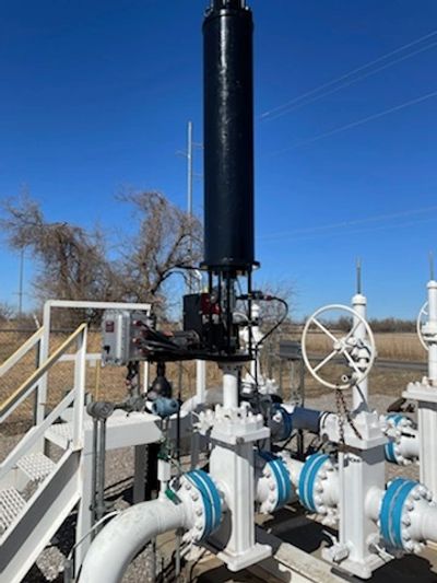 Industrial pipeline equipment under a clear sky.