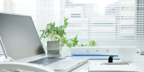 open laptop on desk in a clean office  showcasing janitorial service