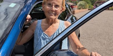 Vollunteer Driver pauses as she gets into the driver's seat of her car.