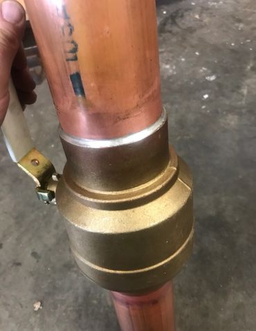 Close-up of a brass valve connected to copper piping.