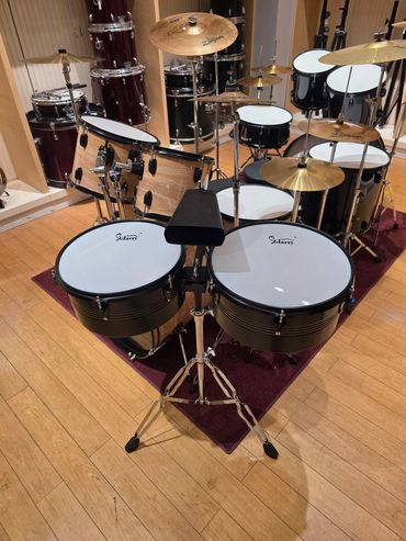 A set of drums and percussion instruments in a room.