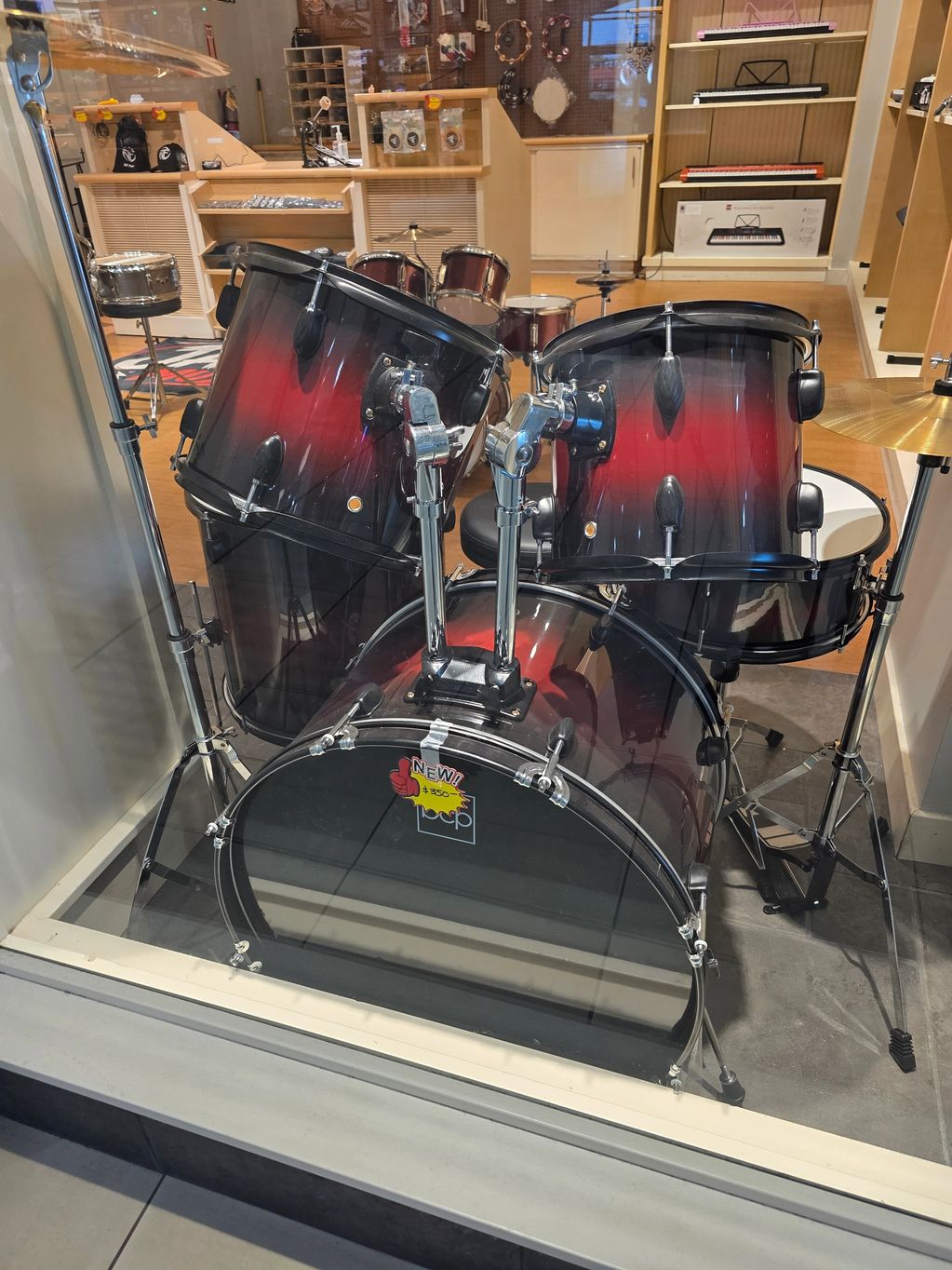 Red and black drum set displayed in a store.