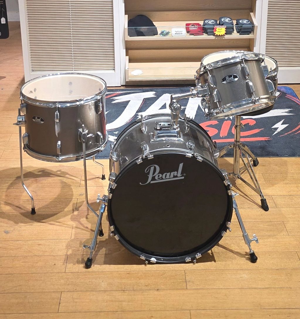 Pearl drum kit on wooden floor.