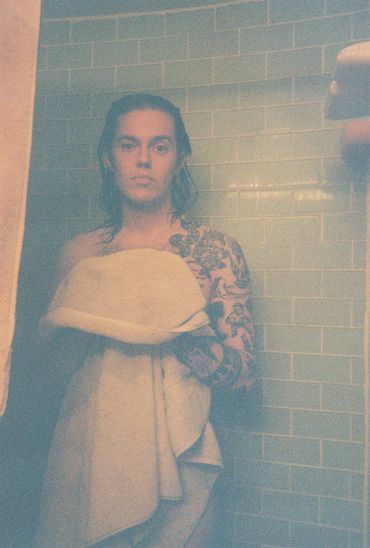 Man in towel in front of tiled bathroom