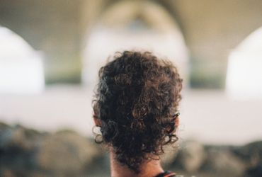 Back of man's head framed by blurry arches in the background