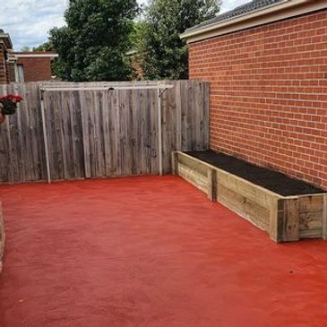 Brick red coloured concrete with timber retaining wall