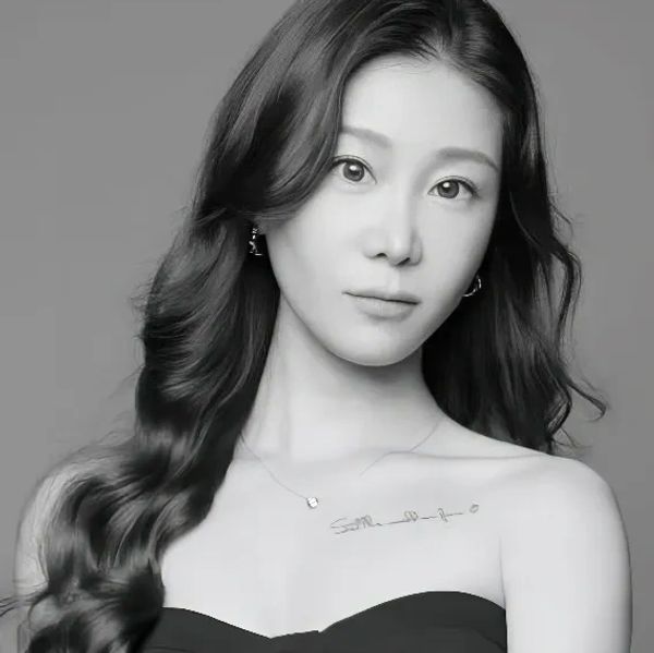 Black and white portrait of a young woman with long wavy hair and a calm expression.