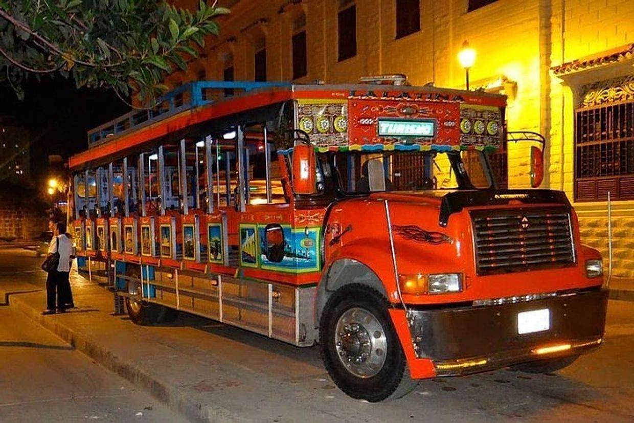 Busetas tradicionales coloridas en la noche.