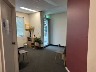 A small, modern waiting area with chairs and plants.