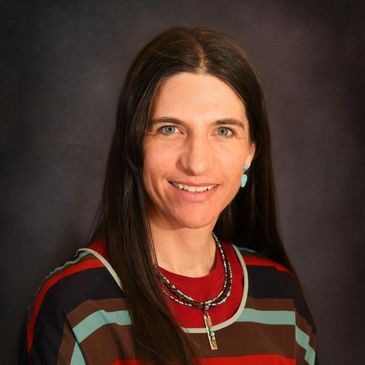 Woman with long brown hair wearing a striped shirt and necklace.