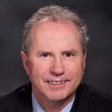 Professional headshot of a middle-aged man in a suit.