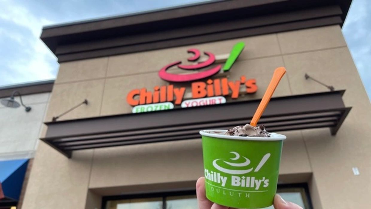 Chilly Billy's frozen yogurt in a green cup in front of the Chilly Billy's storefront