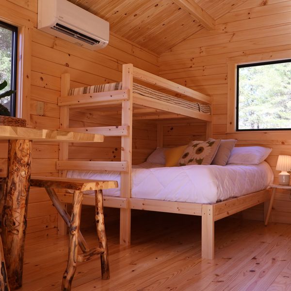 Cozy wooden bunk bed in a rustic cabin room with natural light.