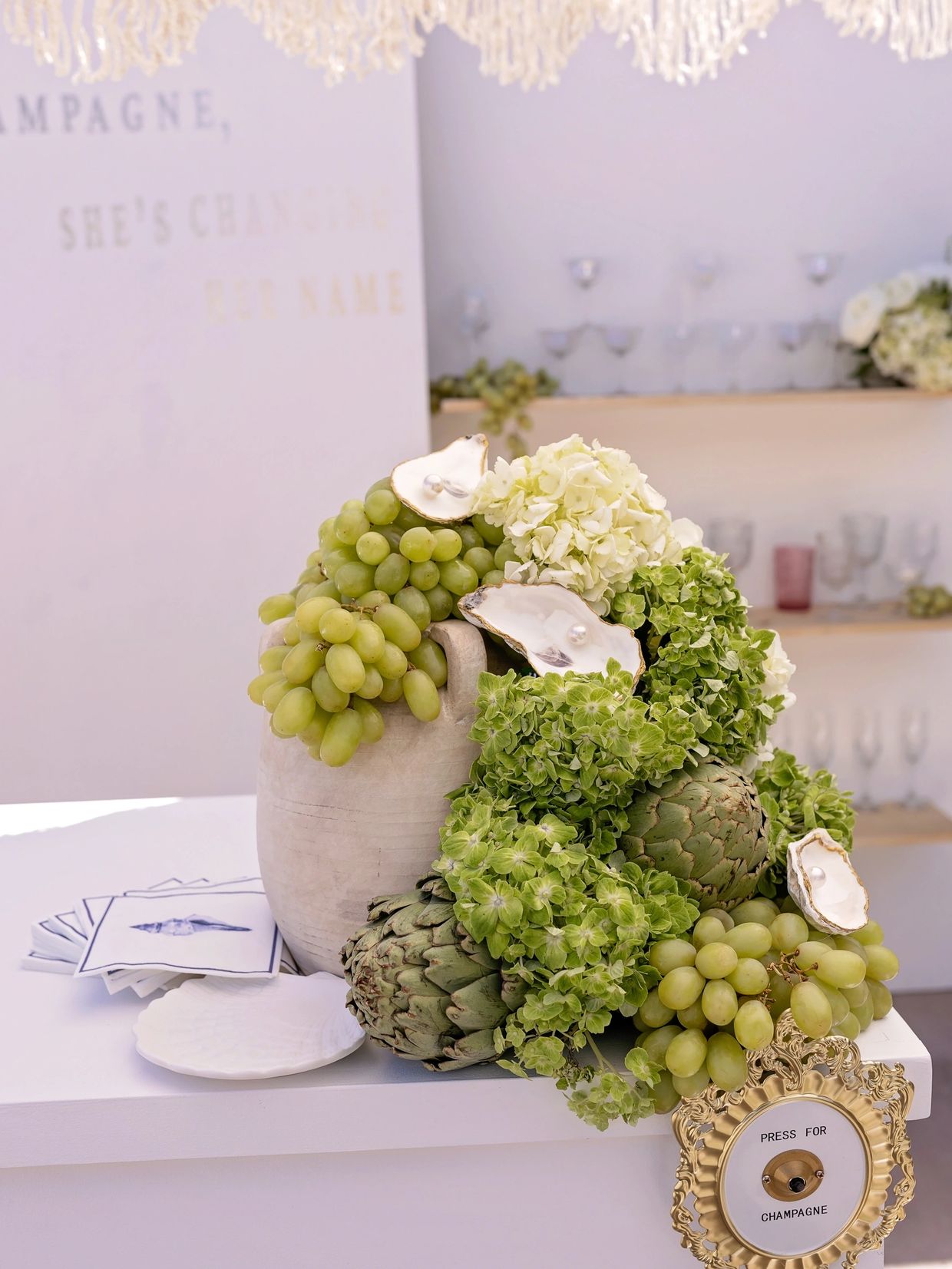 Elegant table centerpiece with grapes, artichokes, and flowers.