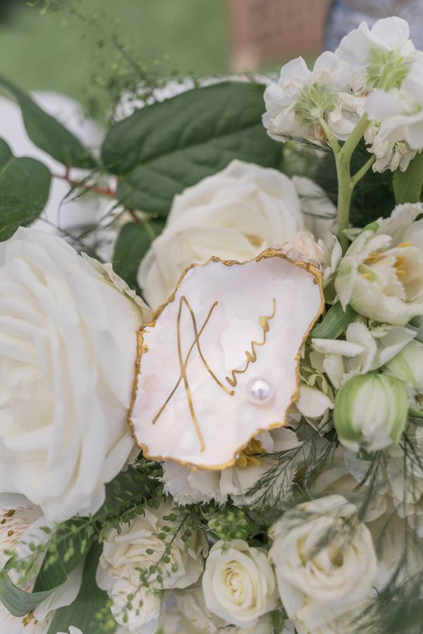 White flowers with a pearl-decorated name card.