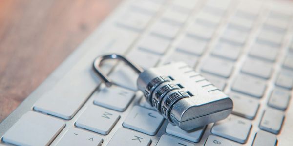 Three security personnel analyzing surveillance footage on multiple monitors.