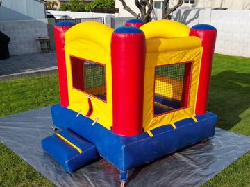 Kids playing on red and yellow bounce house.