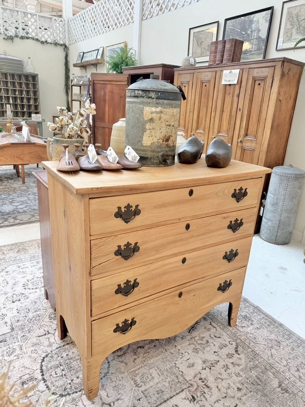 Wooden dresser with vintage decor in a bright, rustic room.
