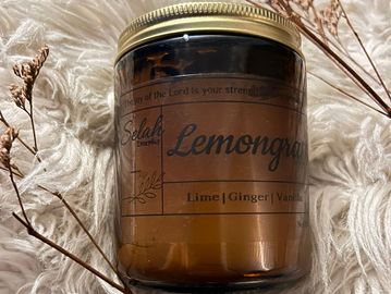 Amber glass jar candle labeled Lemongrass with lime, ginger, and vanilla notes.
