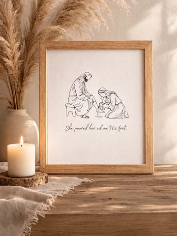 Framed art depicting a woman pouring oil on a man's feet with the caption.