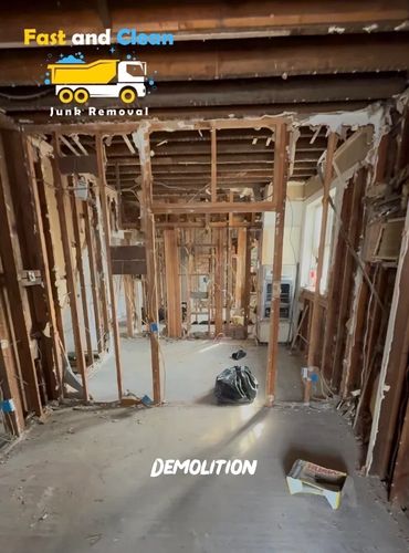 Interior demolition site with exposed wooden framework and debris.