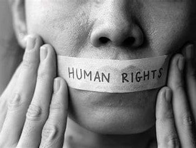 Close-up of a person with tape labeled 'HUMAN RIGHTS' over their mouth.