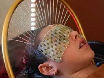Person with a woven blindfold in a wooden hoop.