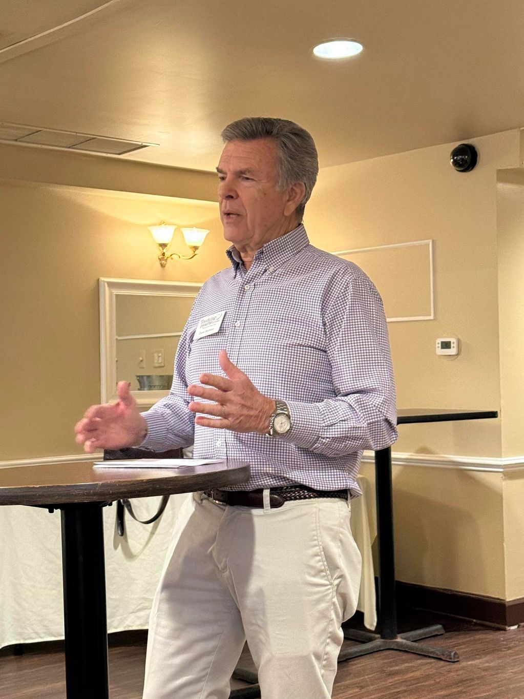 Man speaking at a small indoor gathering.